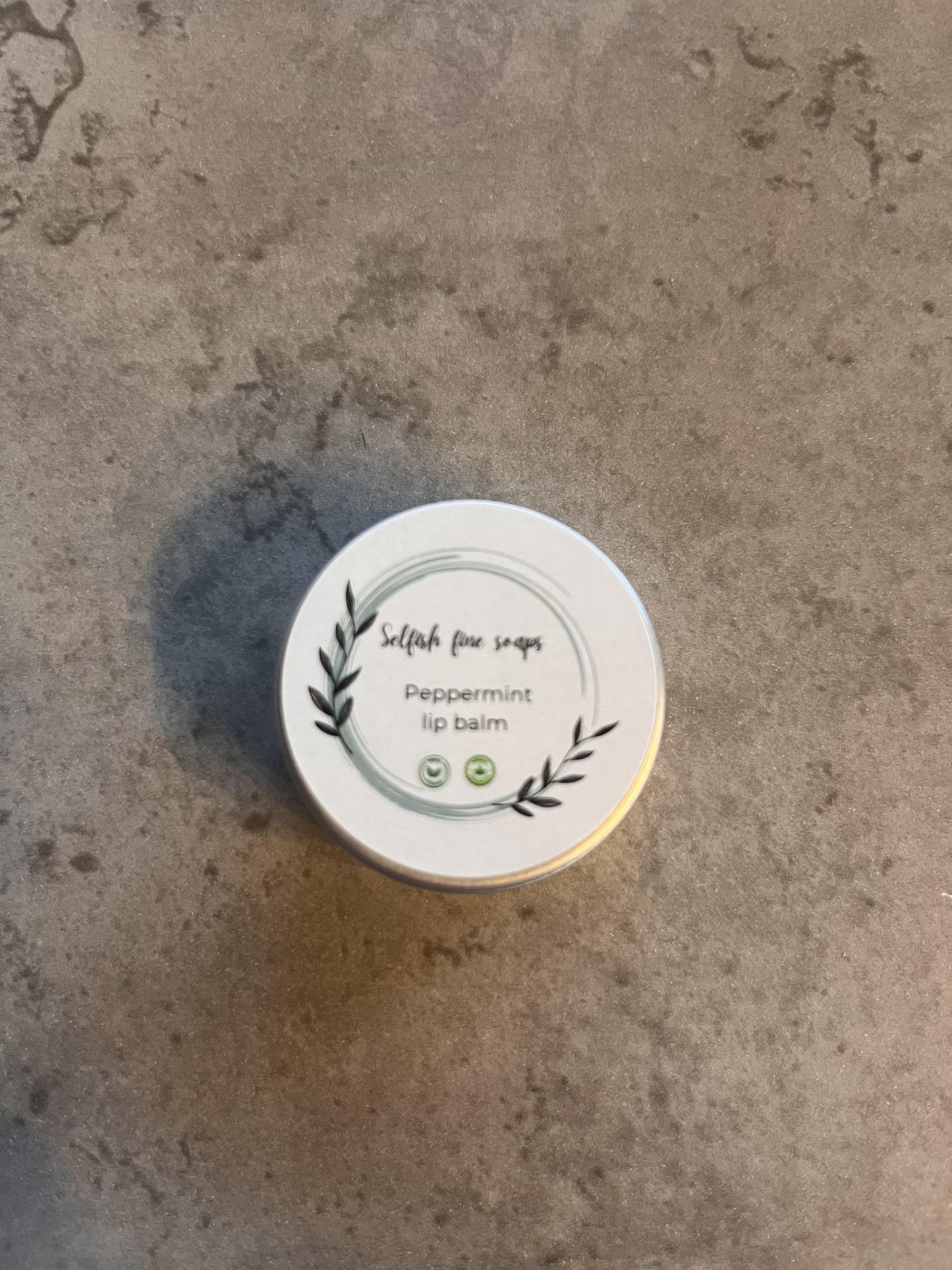 Peppermint lip balm - Selfish Fine Soaps. This is a small tin of handmade lip balm. It is made from fully natural vegan friendly ingredients and enriched with peppermint essential oil.