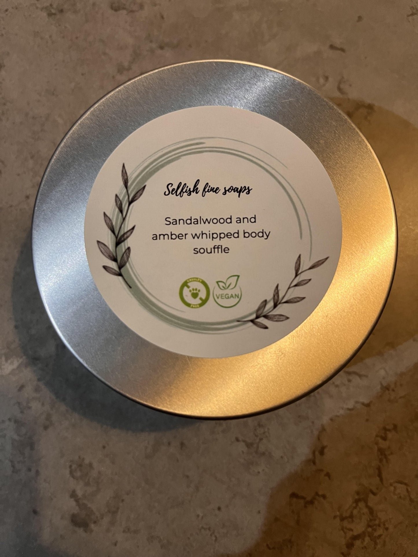 Sandalwood and amber whipped body souffle - Selfish Fine Soaps. This is a round tin of whipped boy souffle handmade from natural vegan friendly ingredients. It is perfumed with sandalwood and amber high quality fragrance oil to achieve a wonderful ever popular product.