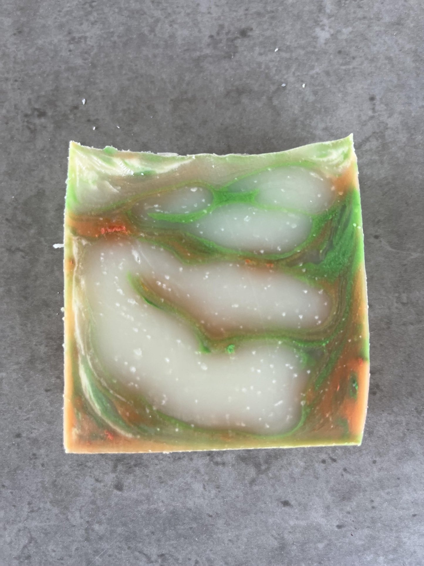 Tropical fruit cold processed soap - Selfish Fine Soaps. This is a bar of handmade cold processed soap made from natural vegan friendly ingredients. It is green, orange and white swirl in colour and smells of tropical fruit.